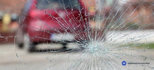 Close-up of a windshield with a spiderweb crack from an impact point