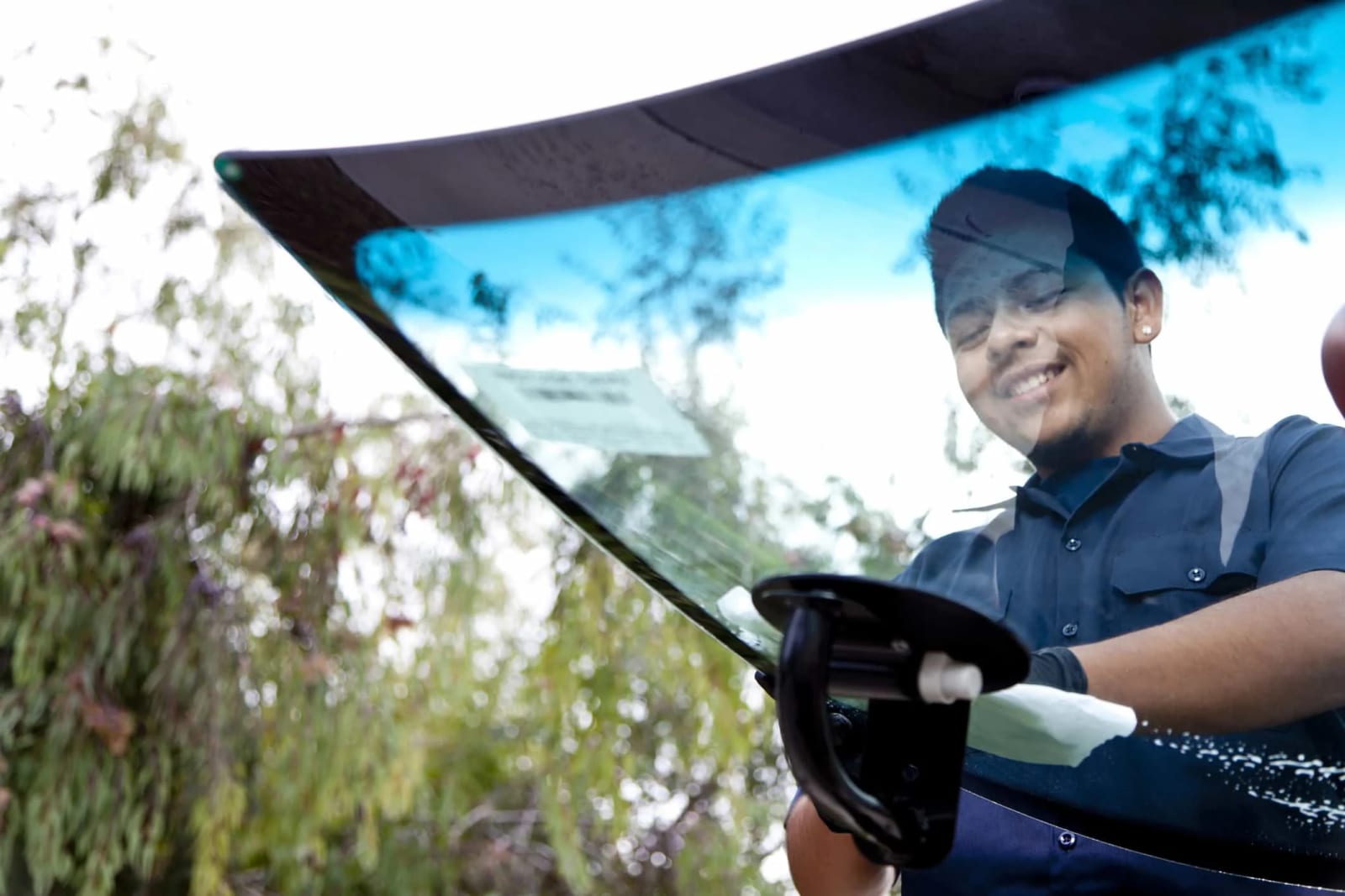 Technician smiling while carrying a windshield