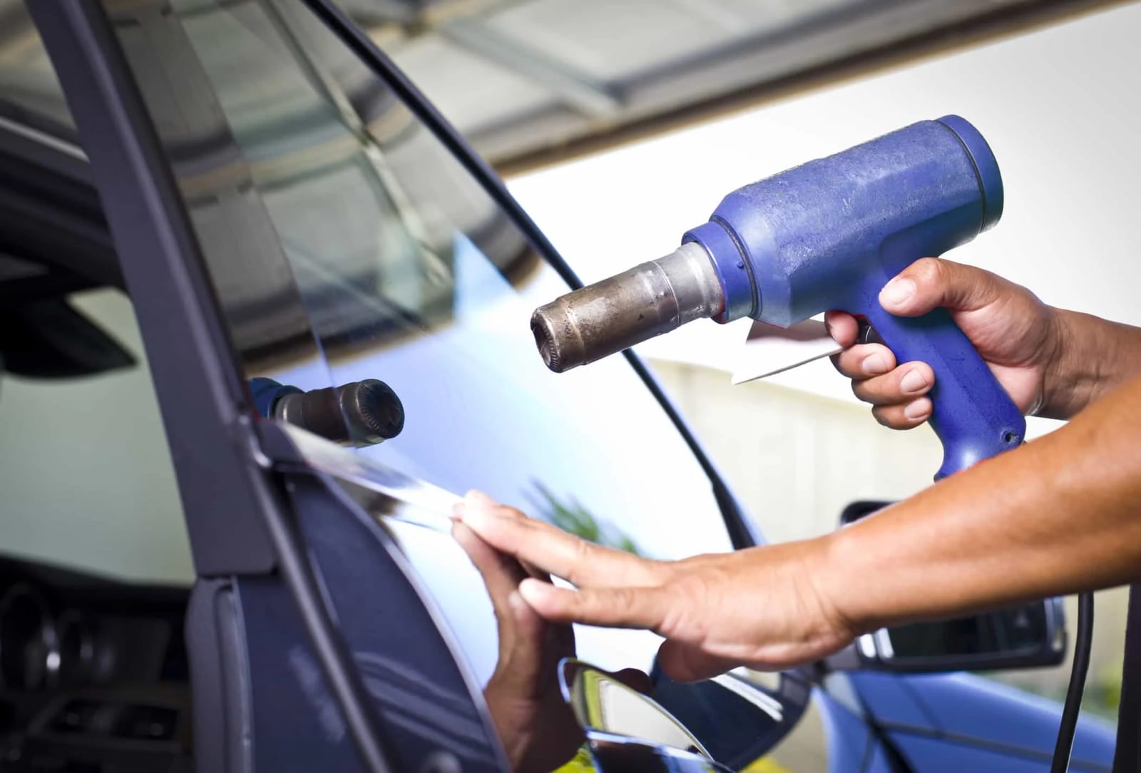 Applying window film to a car door glass with a heat gun